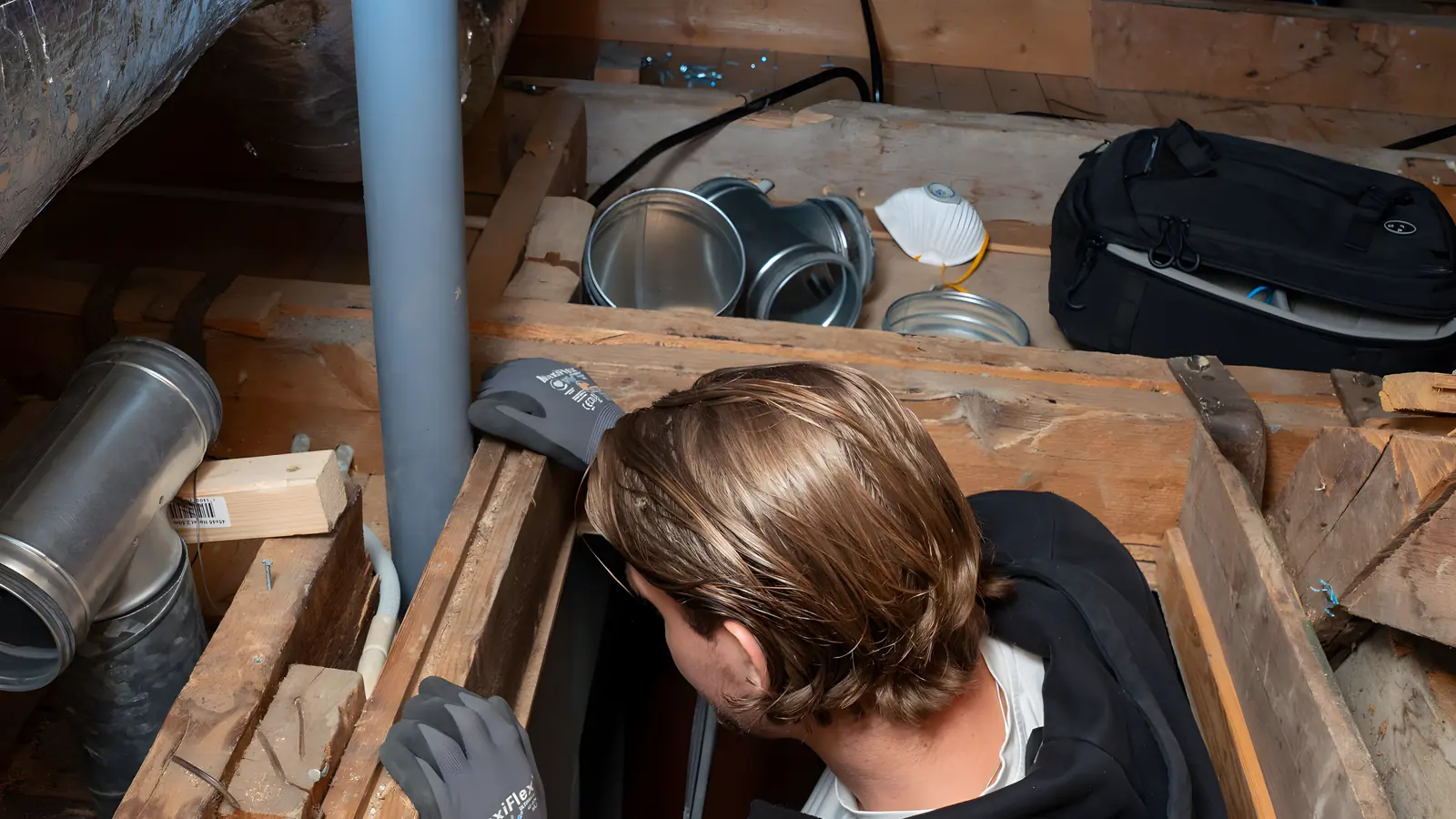 Ventilationstekniker som monterar ventilationskanaler på en vind